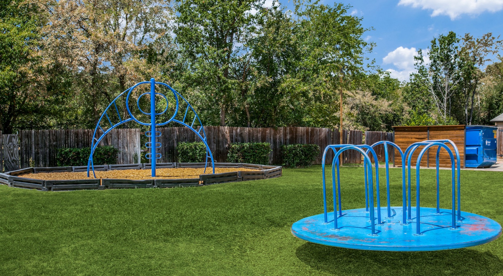 a playground with a blue slide and blue water fountain at The 8500 Harwood