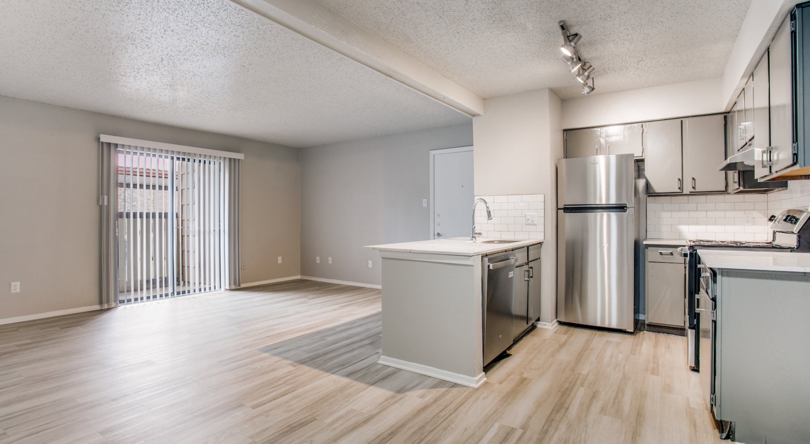 a clean kitchen with stainless steel appliances and hardwood floors at The 8500 Harwood