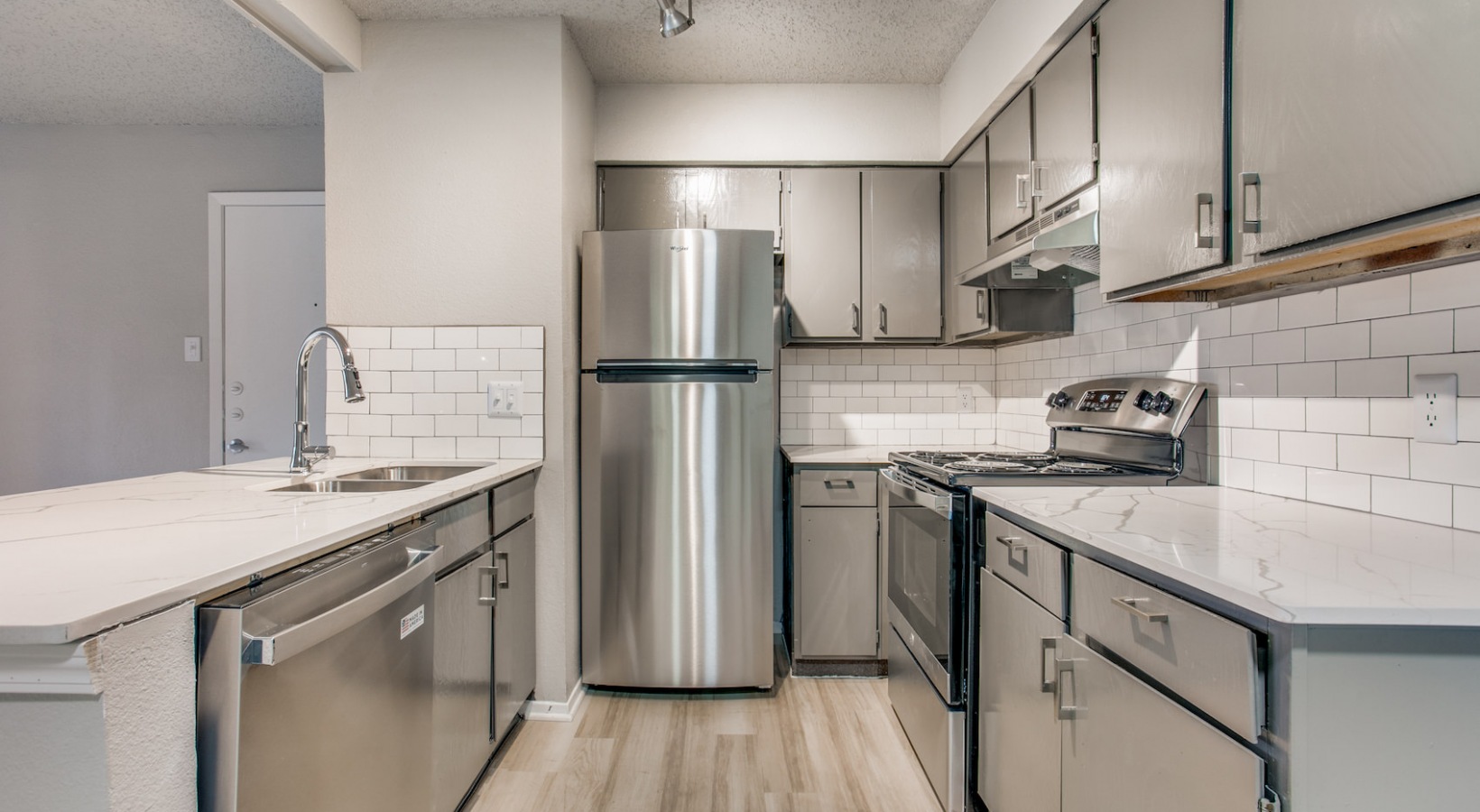 a kitchen with stainless steel appliances and white cabinets at The 8500 Harwood