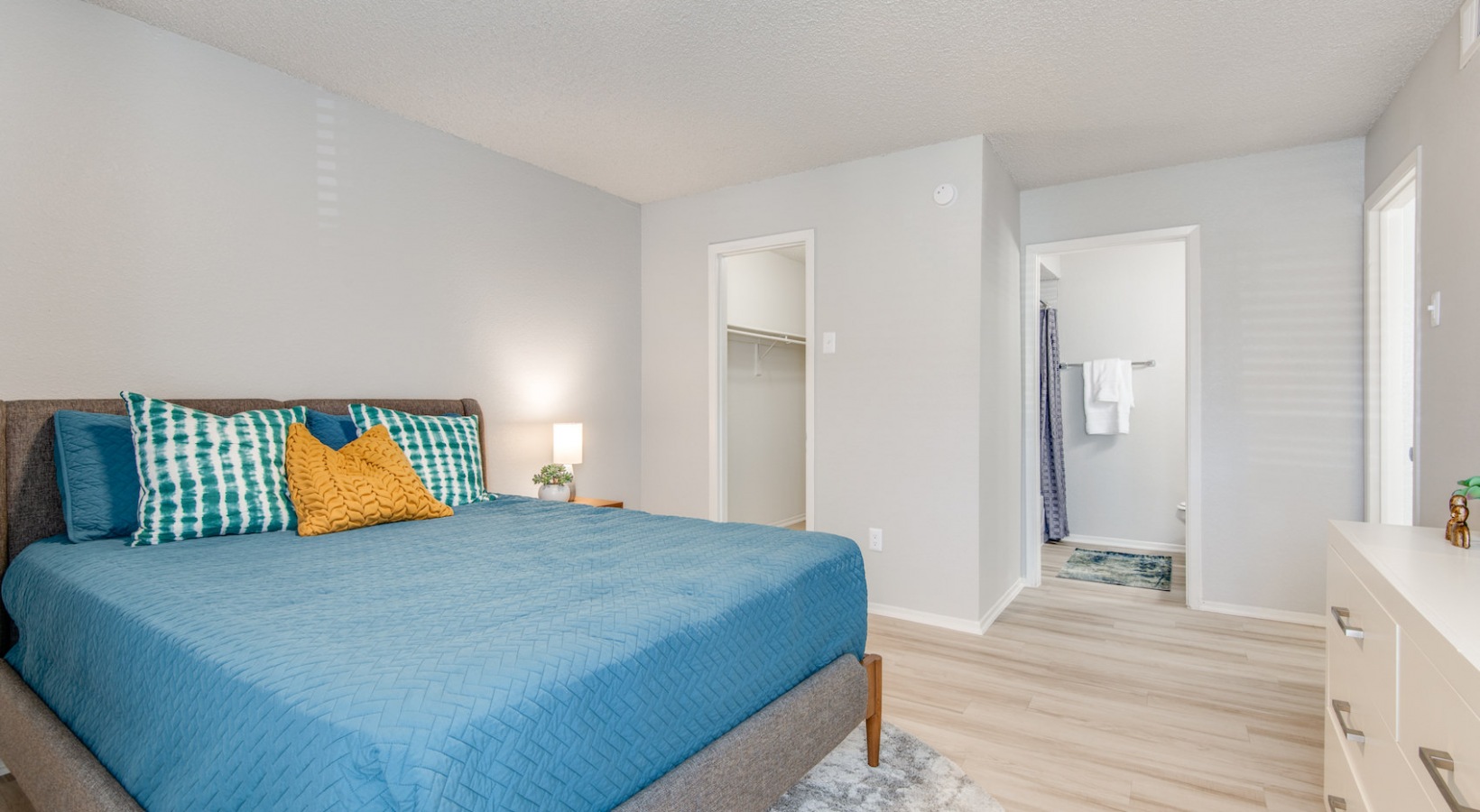 a bedroom with a blue bed and white walls at The 8500 Harwood