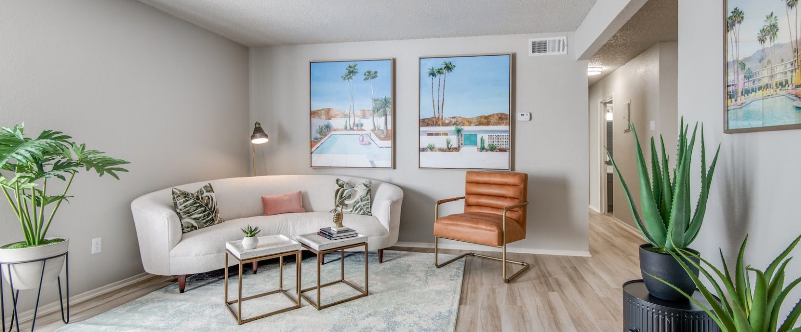 a living room with a couch, coffee table and plants at The 8500 Harwood