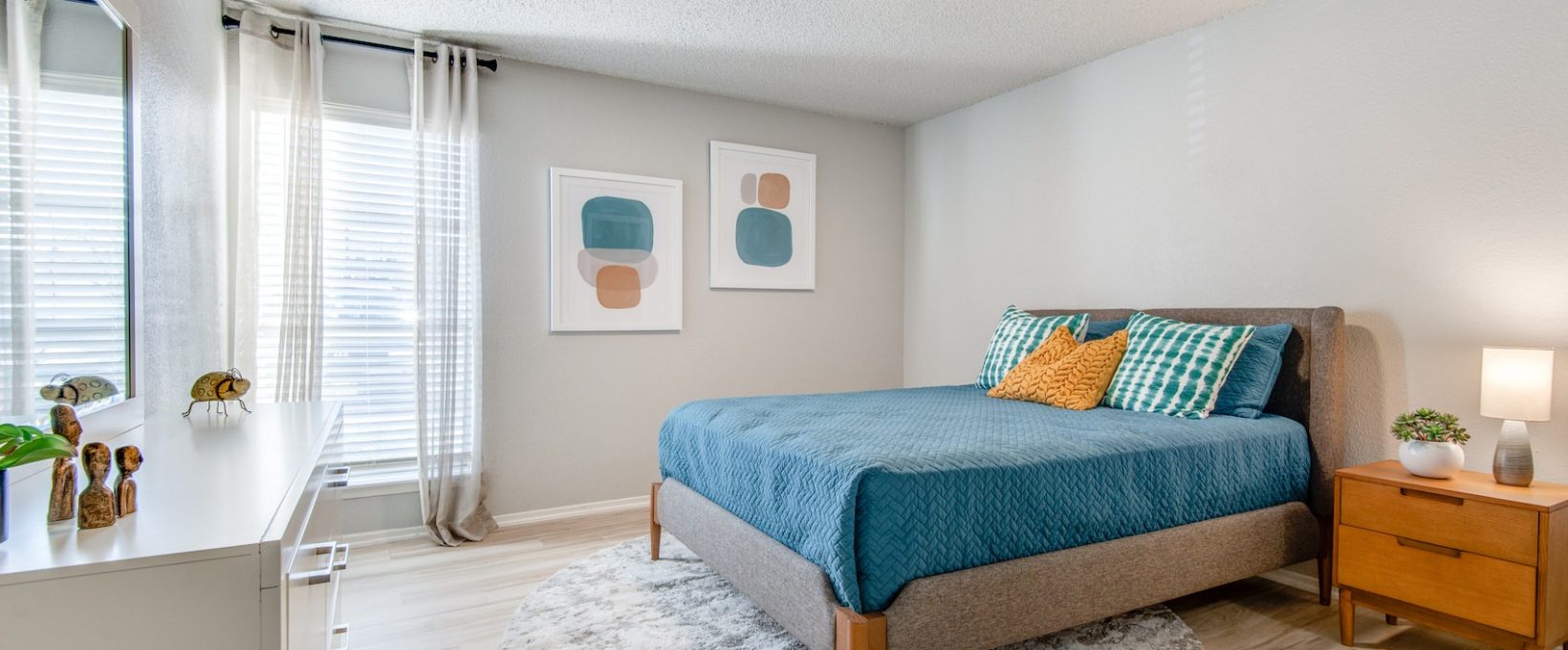 a bedroom with a blue bed and a white dresser at The 8500 Harwood