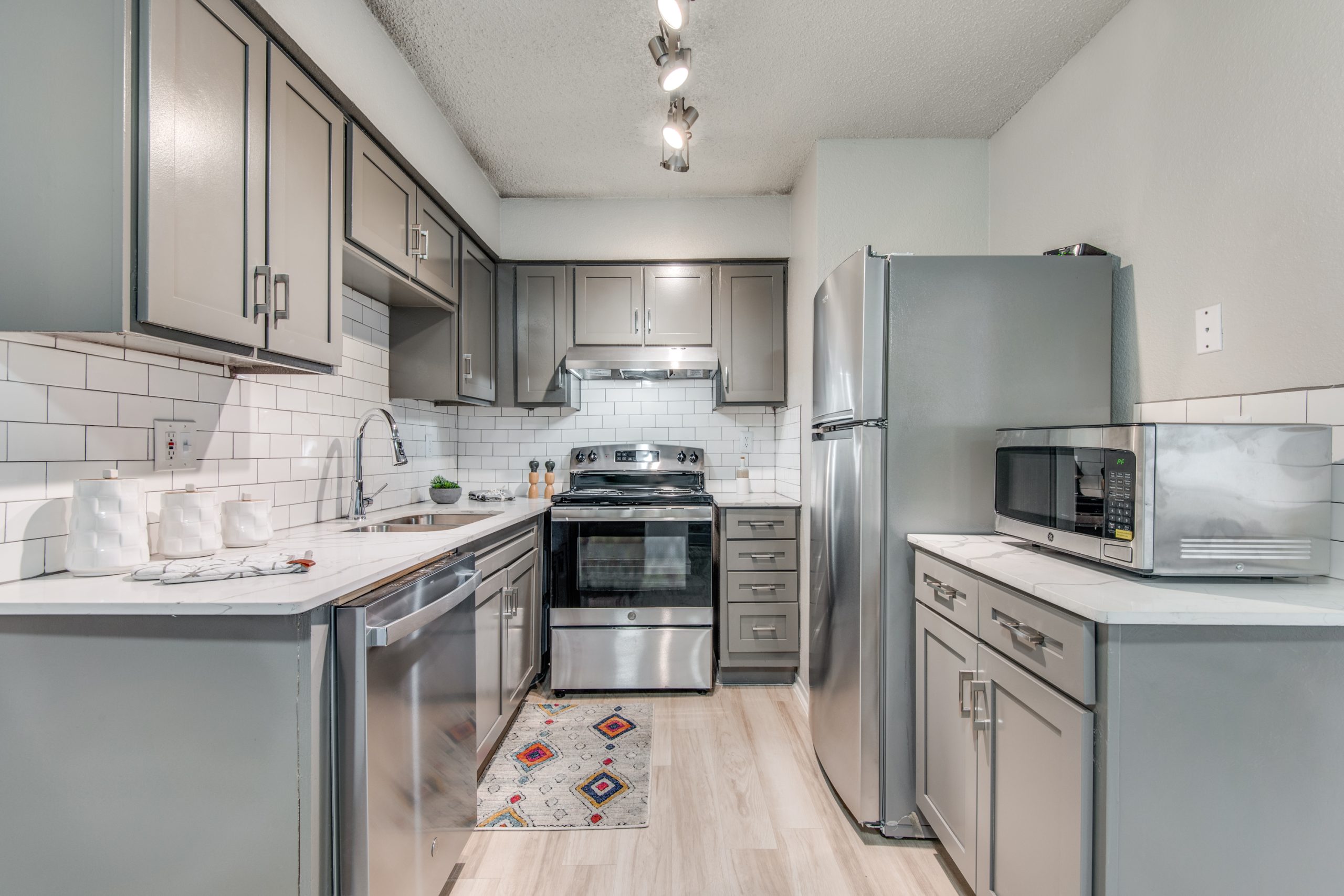 a kitchen with stainless steel appliances and silver cabinets at The 8500 Harwood