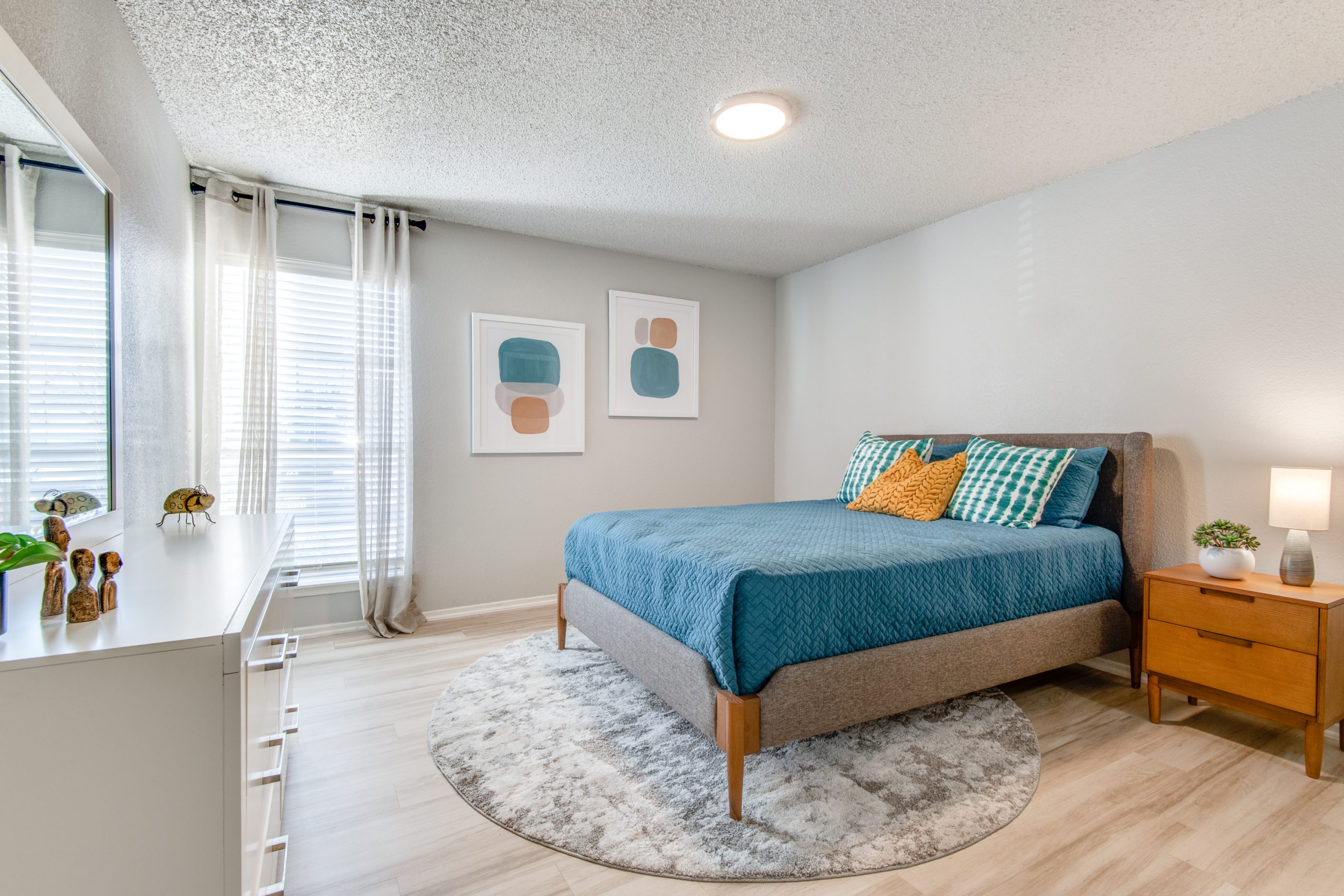 a bedroom with a blue bed and a white dresser at The 8500 Harwood